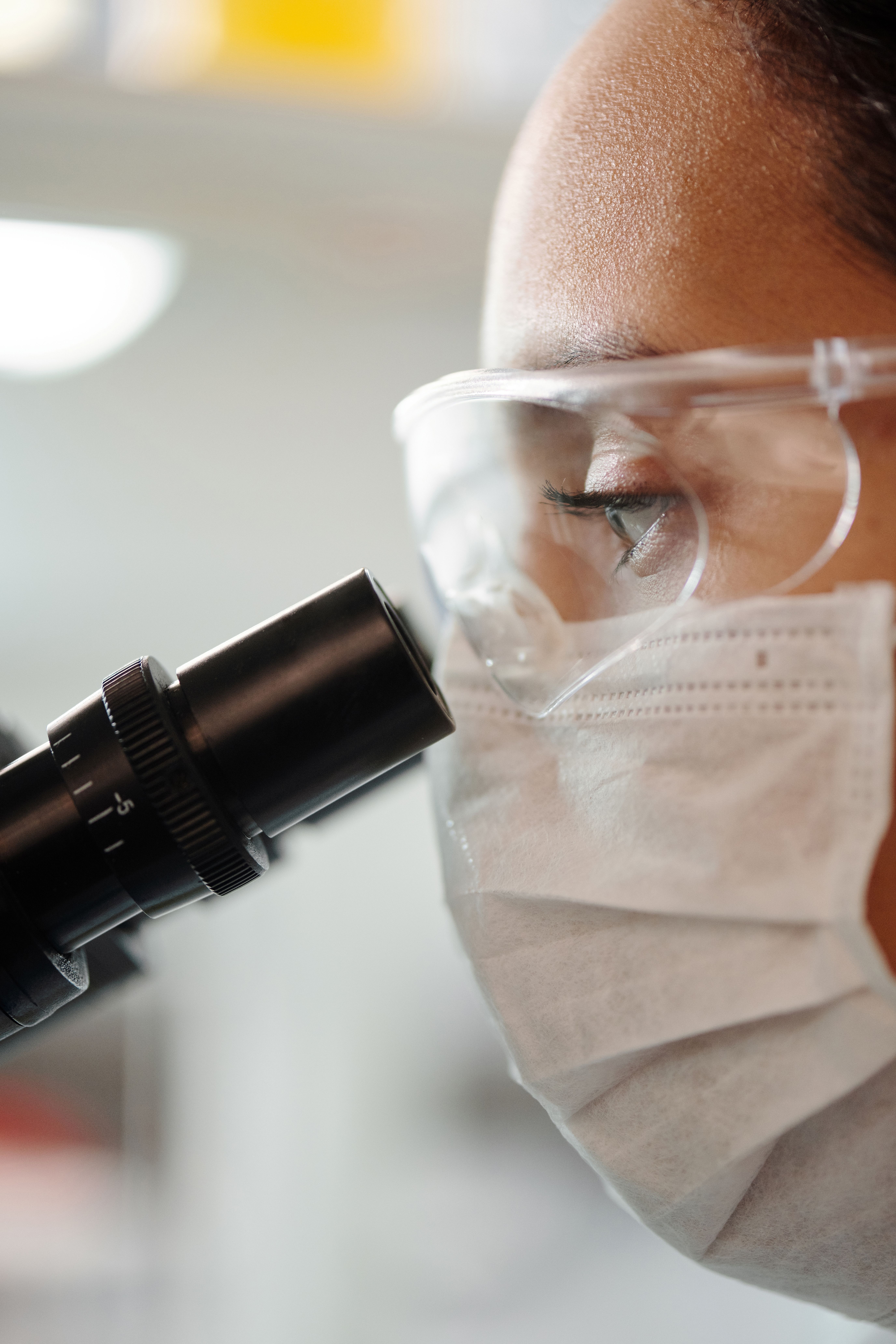 Scientist examining a sample through a microscope